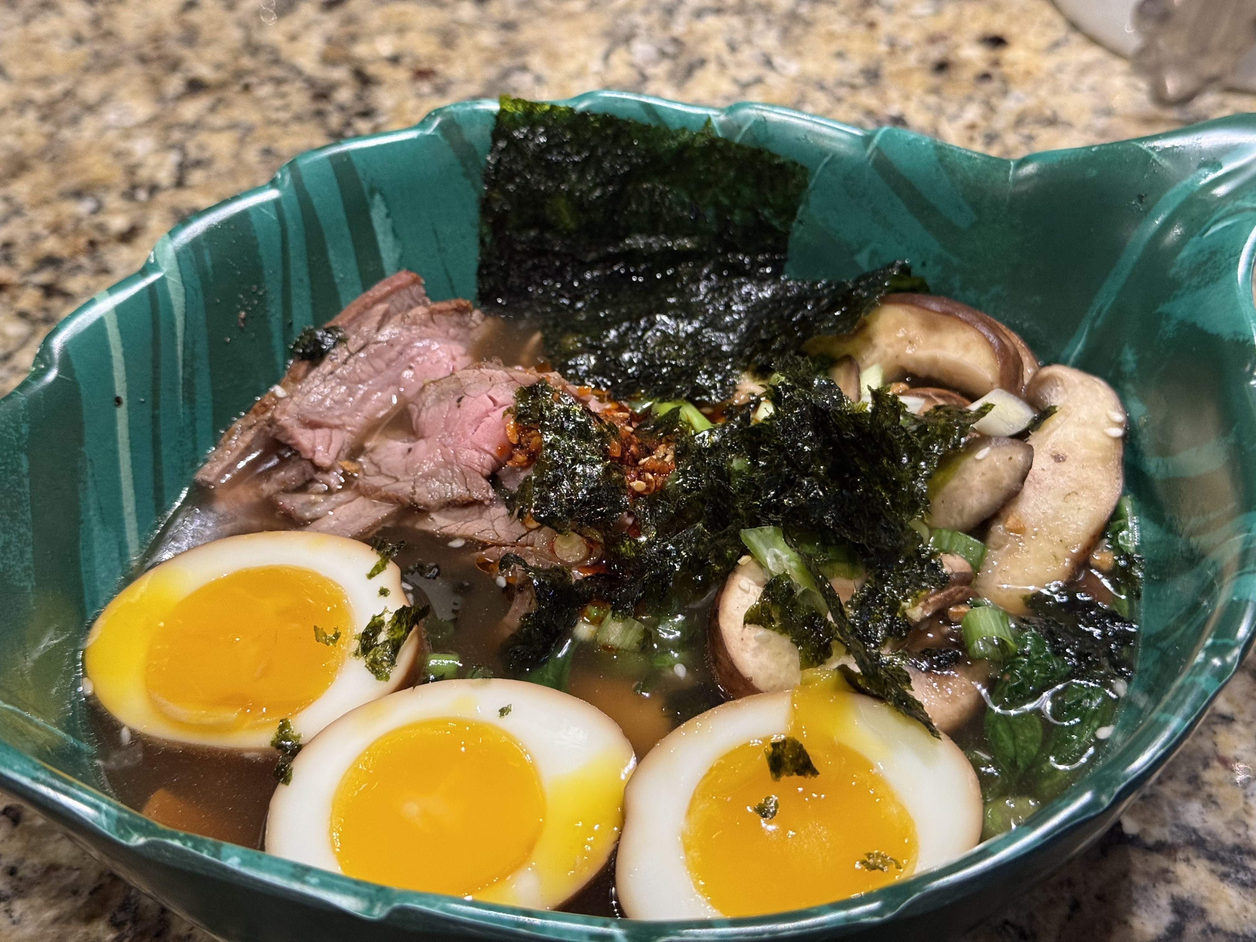 Asian noodle bowl with sliced flank steak, jammy marinated eggs, bok choy, and mushrooms