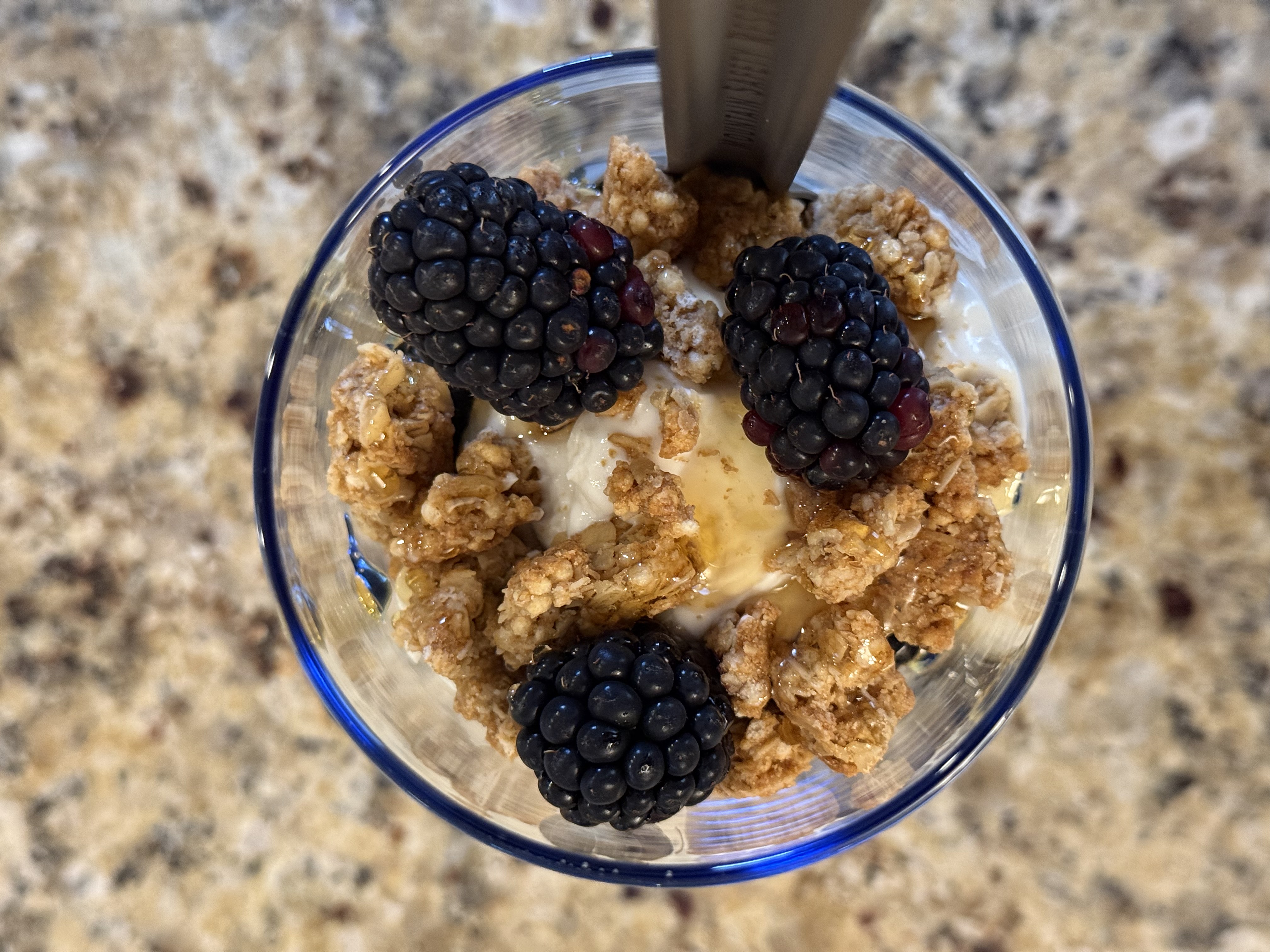 Blackberry parfait topped with honey, granola, and whole blackberries