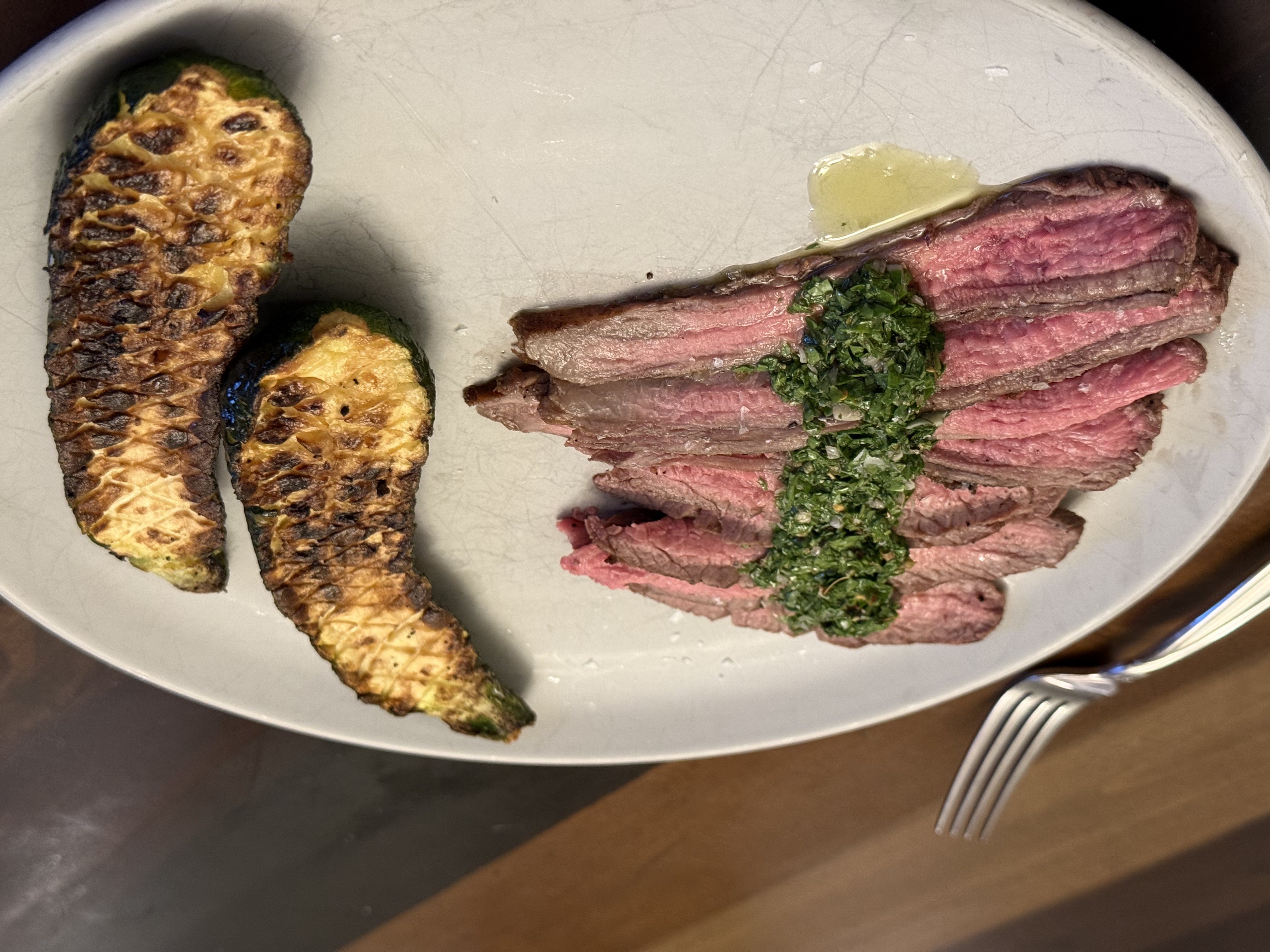 Sliced flank steak with chimichurri and grilled zucchini
