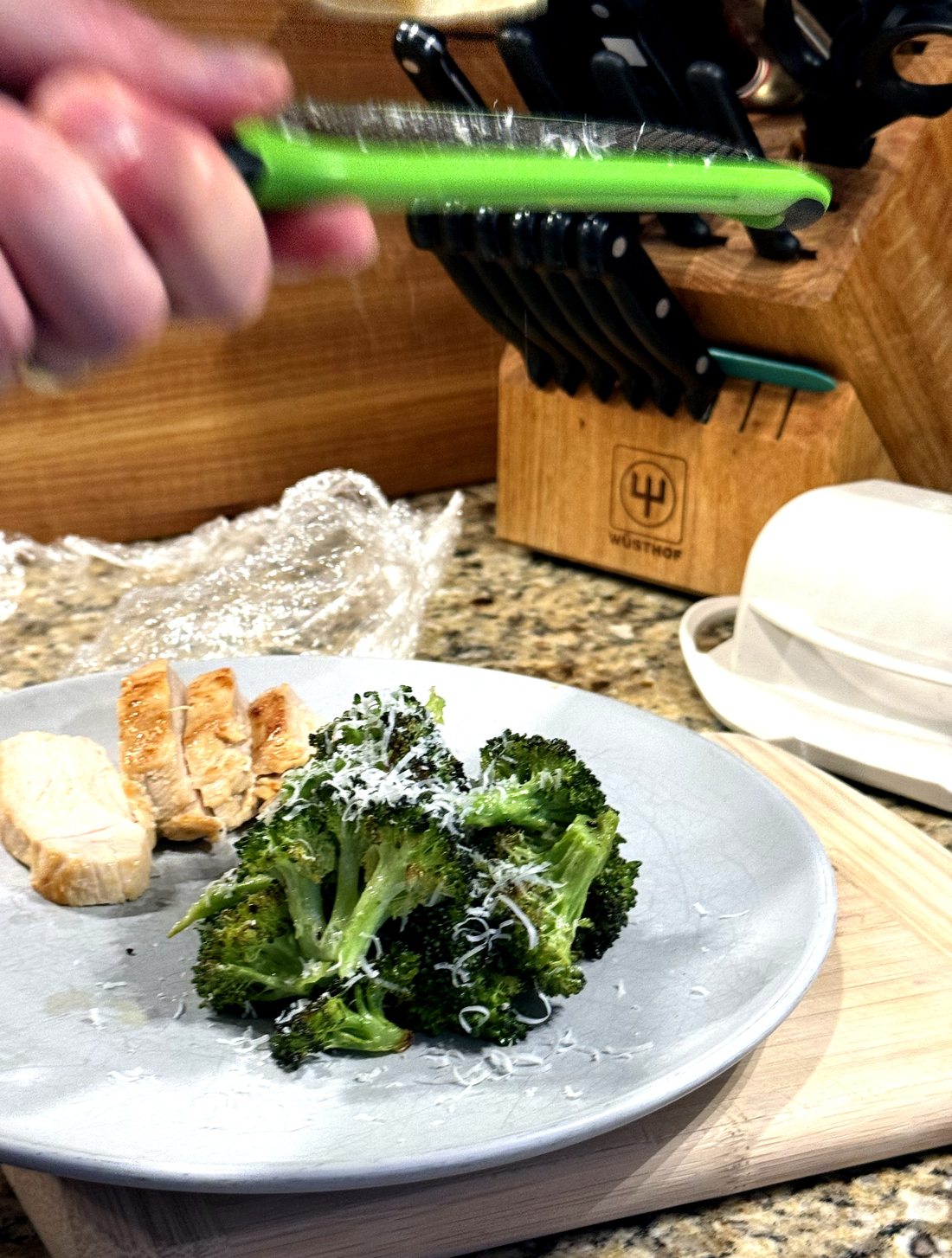 Garlic rosemary chicken breast sliced alongside roasted broccoli finished with lemon and shaved Parmesan