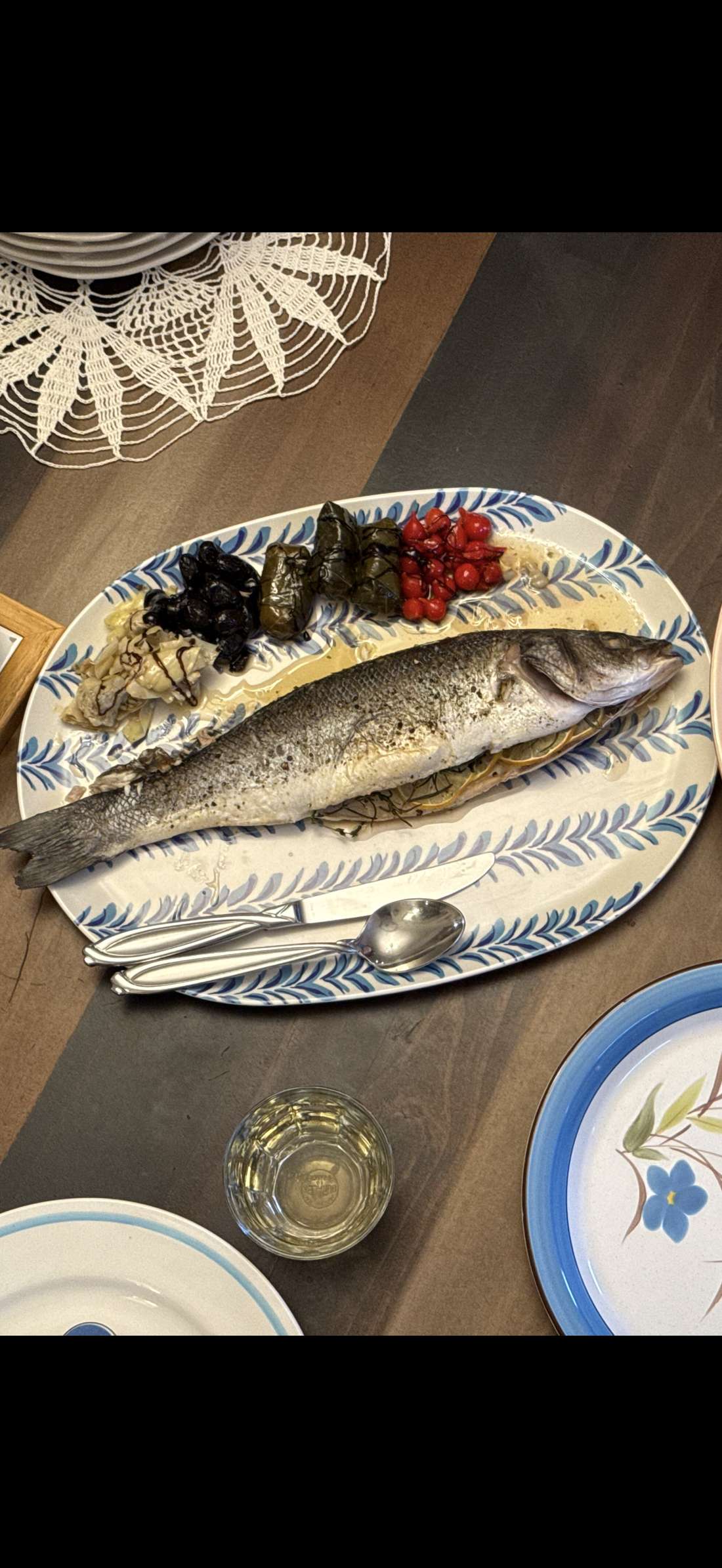 Whole roasted branzino on an Italian blue and white serving platter with beurre blanc